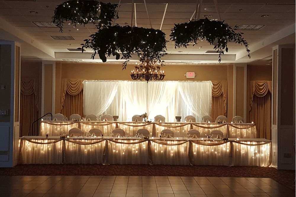 Decorated wedding reception with white tablecloths and lights