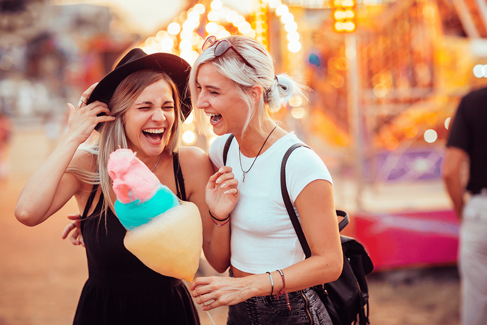two women enjoying cotton candy and the fair