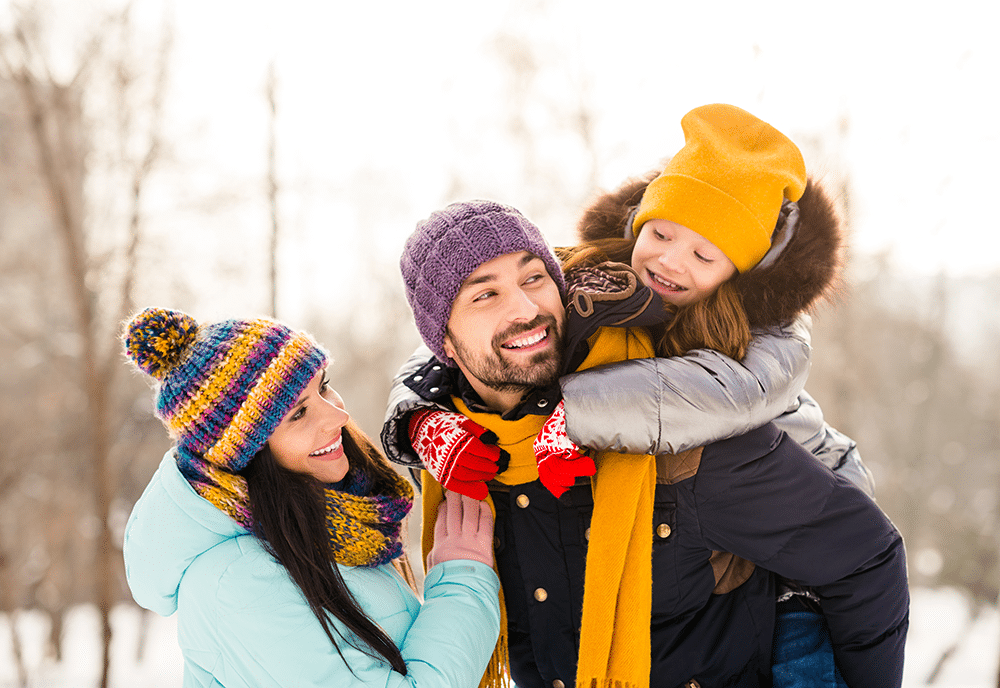 Photo of cheerful family outdoors in snow dressed warmly