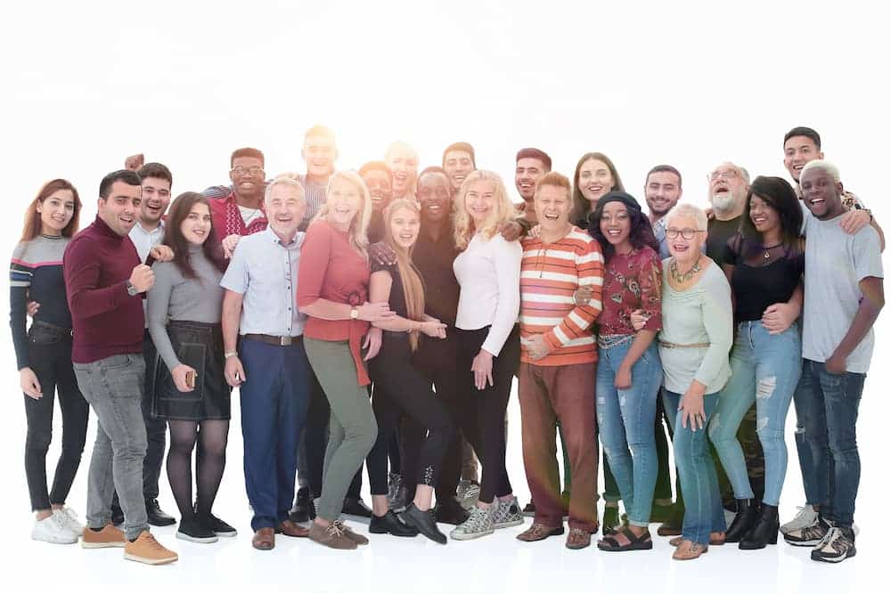 Large multigenerational group of people smiling and posing together for a family or school reunion photo